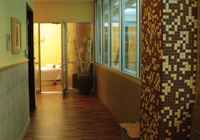 To the right of this hall leading to the treatment rooms, clients can gaze out at the facility's enormous pool.
