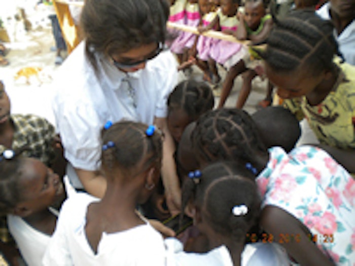 Rinehart of the Sue Mayborn Women’s Center at Metroplex Health System shows some Haitian children her smartphone.