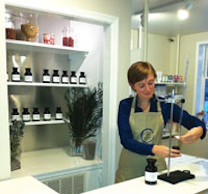 Rebecca Kroll, front desk coordinator of The Still Point Mind and Body, a Wellness Spa in Takoma Park, MD, dispenses essential oil from a burette.