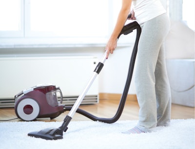 woman using vacuum to clean up dander