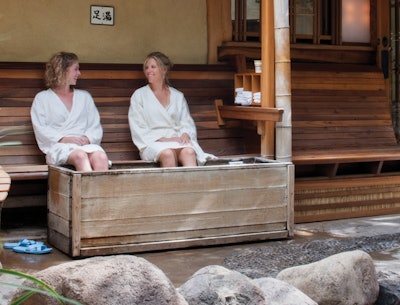 Two women enjoying Ten Thousand Waves spa’s outdoor footbath.