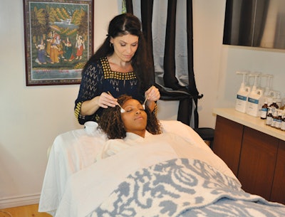 Stacy Cox giving a client a facial
