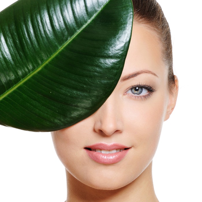 Female face covering with a green leaf
