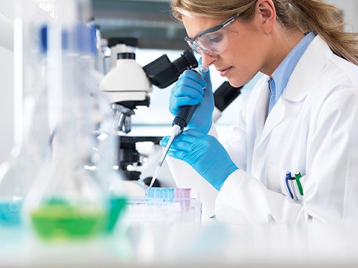 Female scientist pipetting sample into a vial for analytical testing in a laboratory