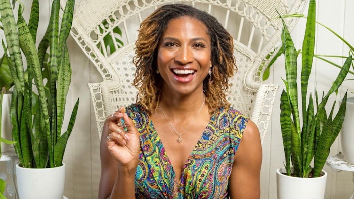 Koya Webb smiling and holding almonds