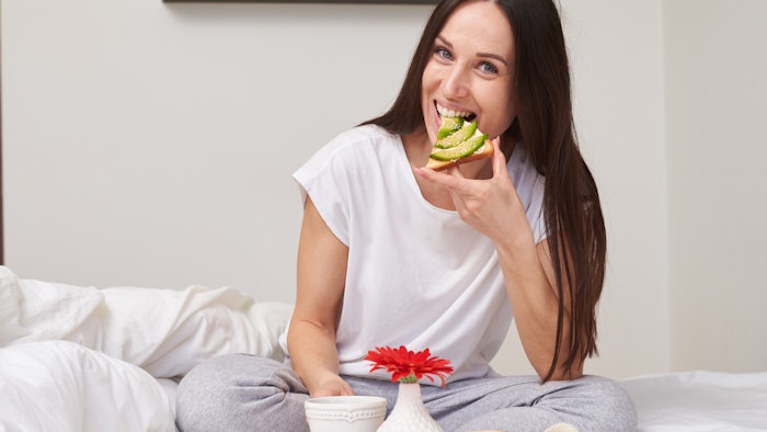 Woman eating Avocado Toast in Bed