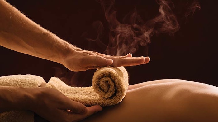 Woman getting hot towel on her back