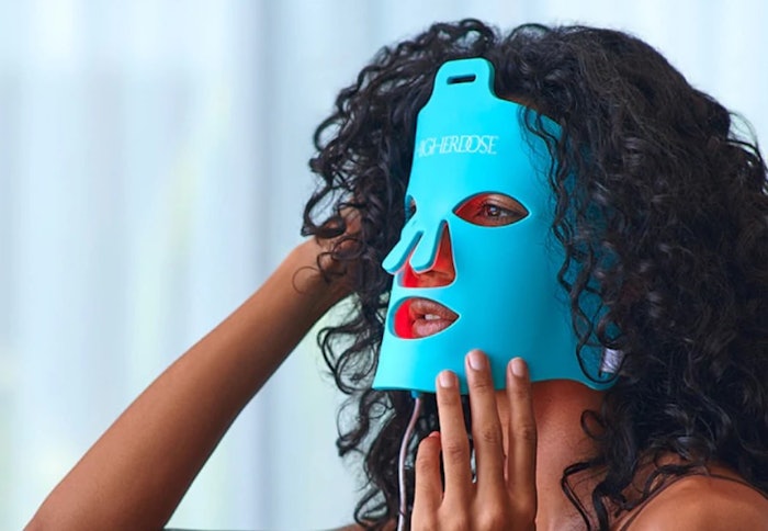 Woman wearing HigherDOSE Red Light Face Mask