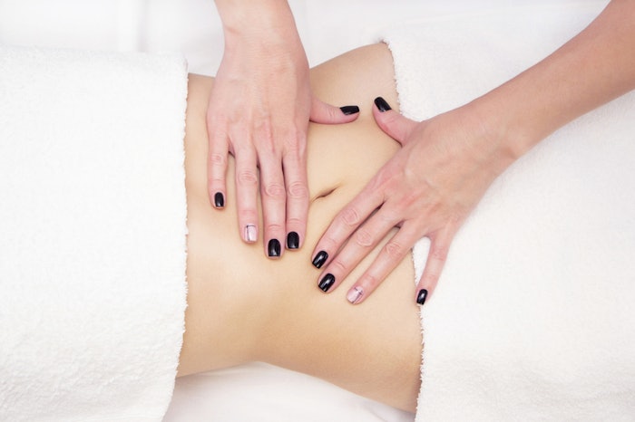 Massage Therapist Massaging a Womens Stomach. Massage and body care.