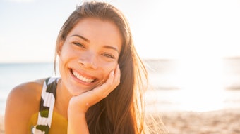 woman with beautiful hair smiling in the summer sun