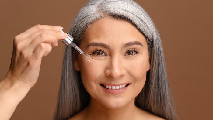 woman putting on anti-aging serum