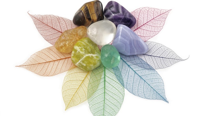 healing chakra crystals on colorful leaves