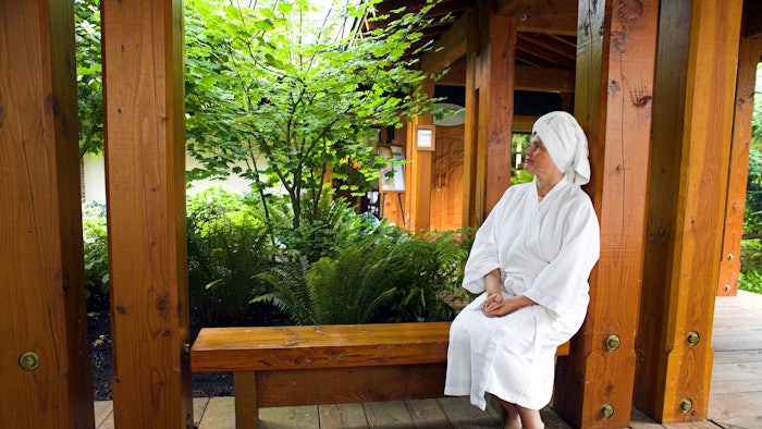 woman in robe and head towel enjoying nature spa