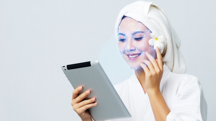 Woman at spa receiving face skin care scan with a tablet