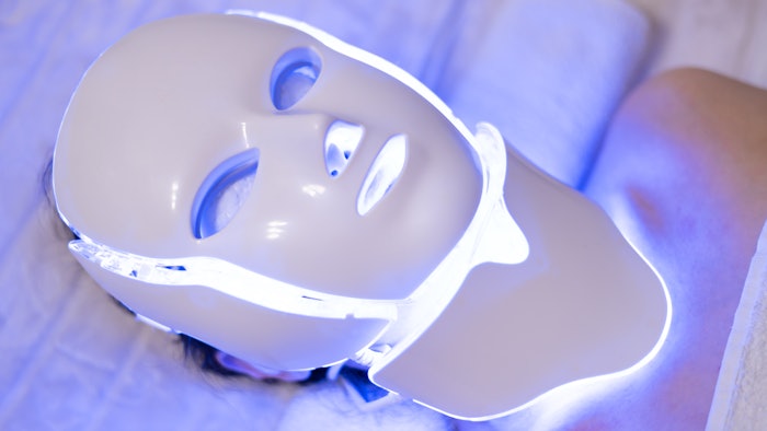 Woman wearing LED light therapy face mask in spa treatment. Health and beauty. Cosmetic procedure for face.