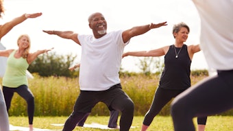 Group Of Mature Men And Women In Class At Outdoor Yoga Retreat