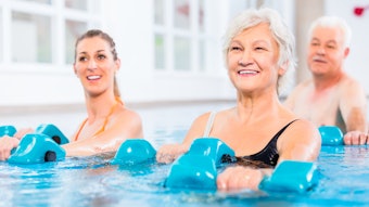 People young and senior in water gymnastics physiotherapy with dumbbells