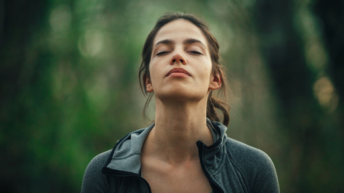 woman closing eyes embracing nature