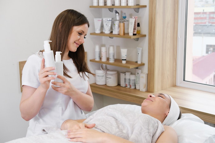 Esthetician offering skin care products to client