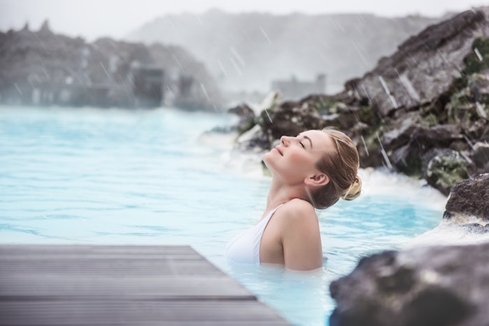 Woman enjoying blue lagoon in Iceland, sky lagoon