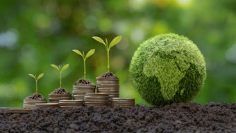 Green Globe with world map and stack of silver coins the seedlings are growing on top. Concept of Green business, finance and sustainability investment. Carbon credit.