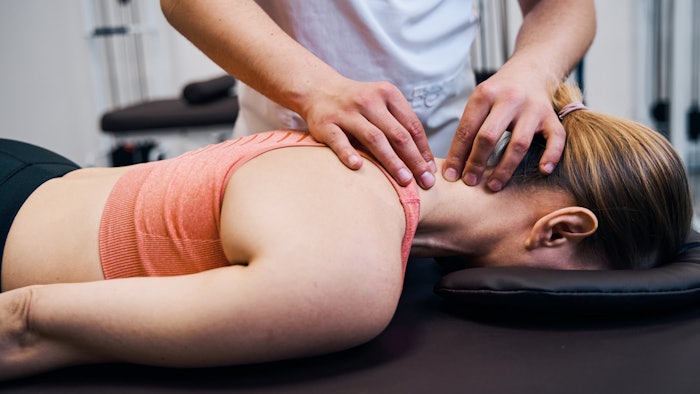 woman getting neck massage in workout clothes