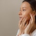 woman with acne looking in mirror