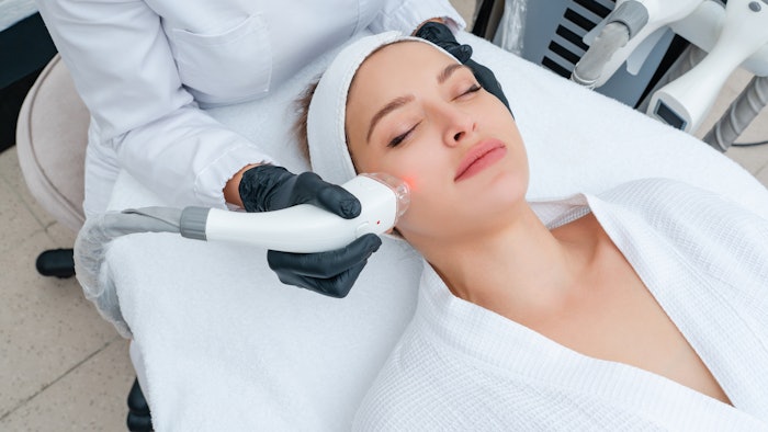 Young woman receiving laser treatment in cosmetology clinic
