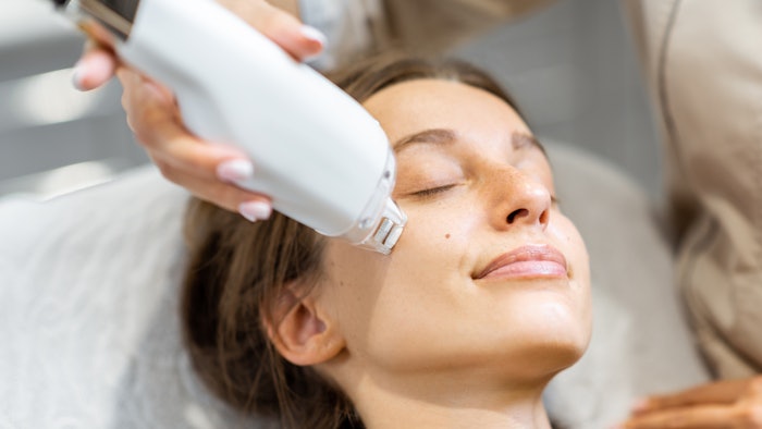 Portrait of a young woman during a facial rejuvenation treatment at medical SPA. LaseMD procedure concept