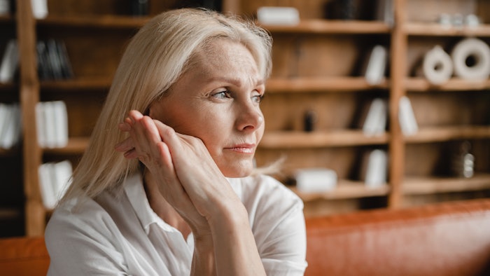 stressed sad tired exhausted caucasian middle-aged mature businesswoman freelancer relaxing on the couch sofa