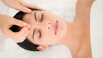 Woman in facial acupuncture therapy