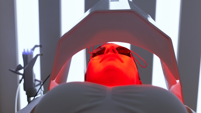 Cosmetology. Woman Face At Red Light Treatment At Beauty Clinic