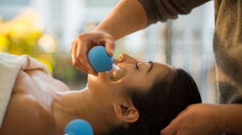 Young Woman receiving facial rejuventation cupping in spa wellness center