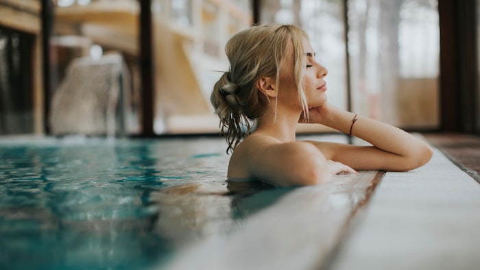 Young woman relaxing in spa swimming pool