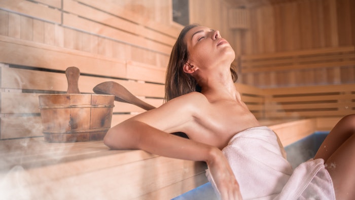 Beautiful young woman relaxing in Finnish sauna
