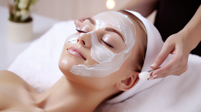Beautiful young woman with a mask on her face. Skin care and treatment, spa, natural beauty and cosmetology concept