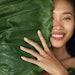 Beauty face. Woman model with natural makeup behind green leaf