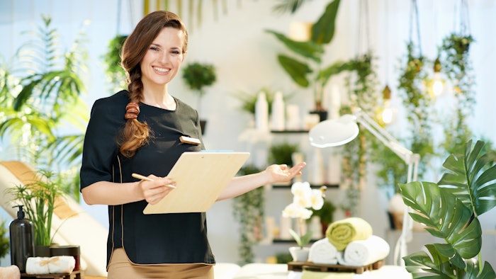 smiling 40 years old woman worker in modern beauty studio