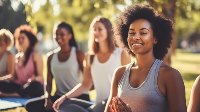 Diverse group of women practicing yoga in the park