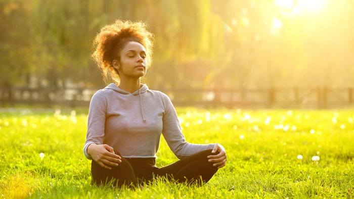 African american woman meditating in nature