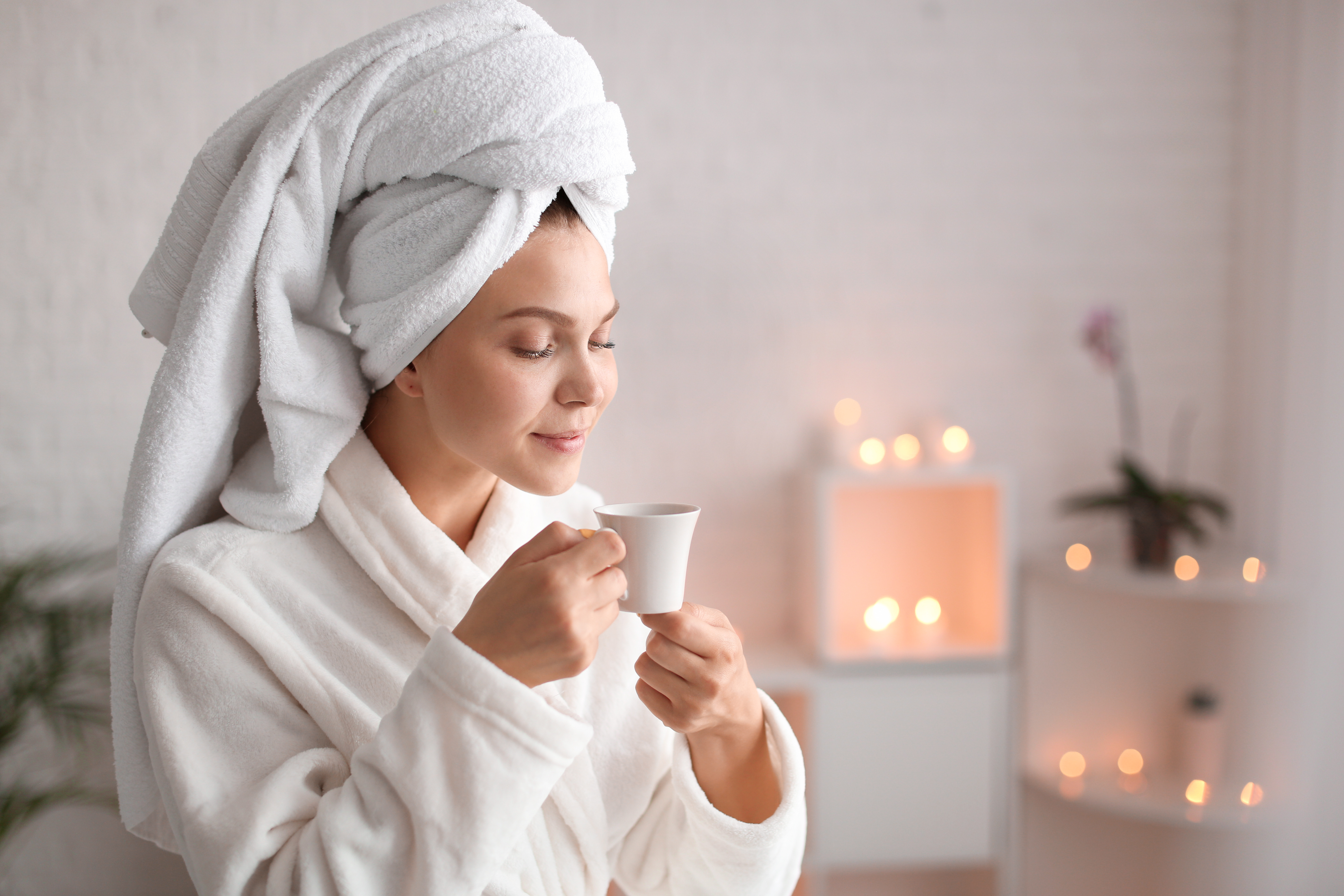Beautiful young woman with cup of tea relaxing in spa salon By Pixel-Shot