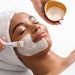 Top view of beauty therapist applying face mask