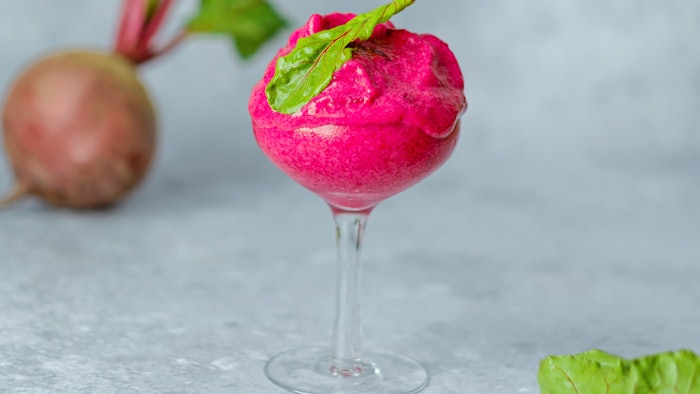 Magenta vegan ice cream with frozen beetroot, banana, avocado and coconut milk in glass on a gray background. A healthy cold vegan dessert.