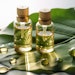 bottles of skin care oil sitting on a green leaf