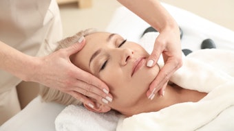 Mature woman receiving face massage in wellness spa