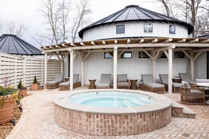 Exterior of The Spa at Nicewonder Farms and Vineyards, white yurt with lounge chairs and hot tub in foreground