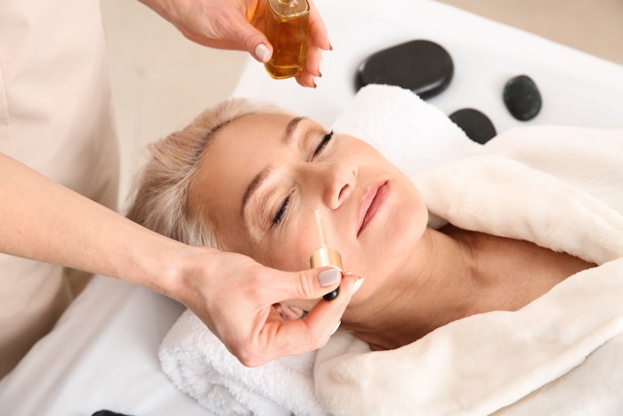 older woman getting an anti-aging facial in the spa