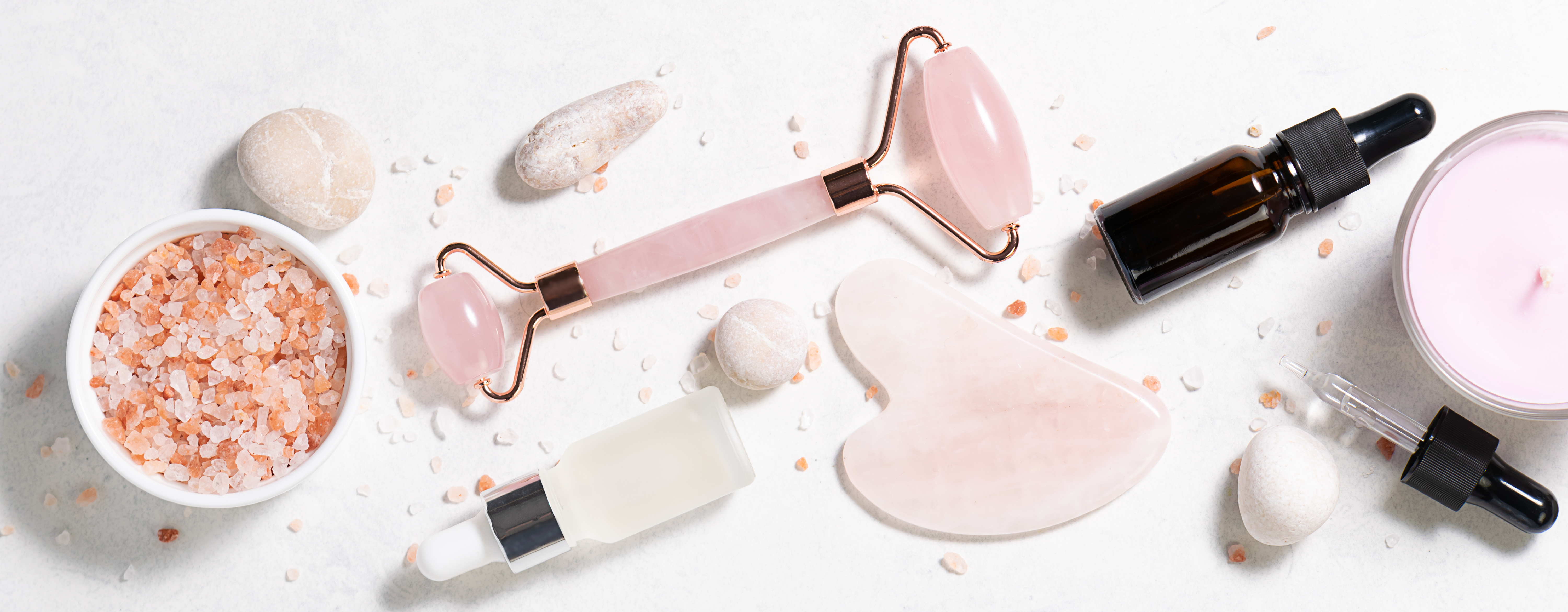 Skin care cosmetic products and Chinese Gua Sha massage tools on white marble background top view. Anti age face care procedures.