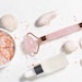 Skin care cosmetic products and Chinese Gua Sha massage tools on white marble background top view. Anti age face care procedures.