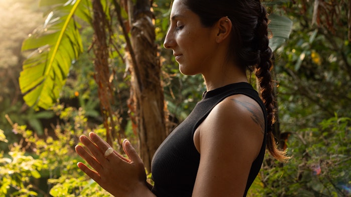 Woman standing in forest doing yoga